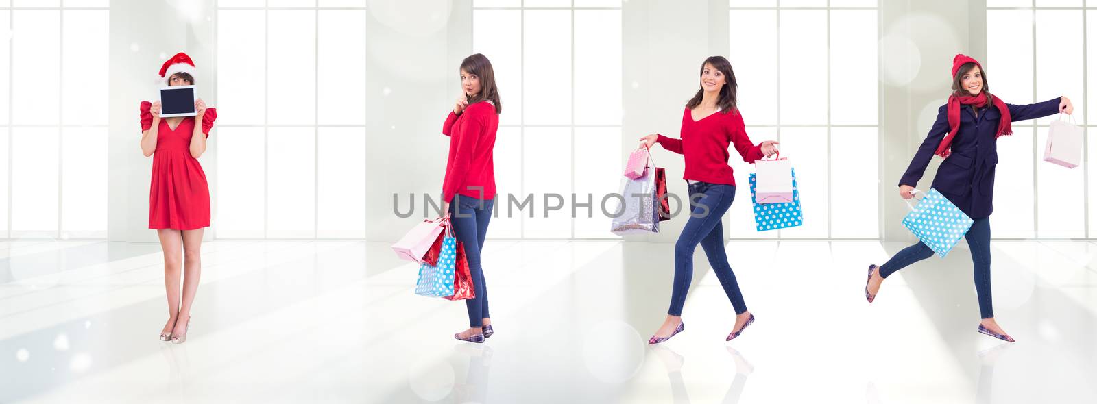 Festive brunette holding gift bags against twinkling lights over room with windows