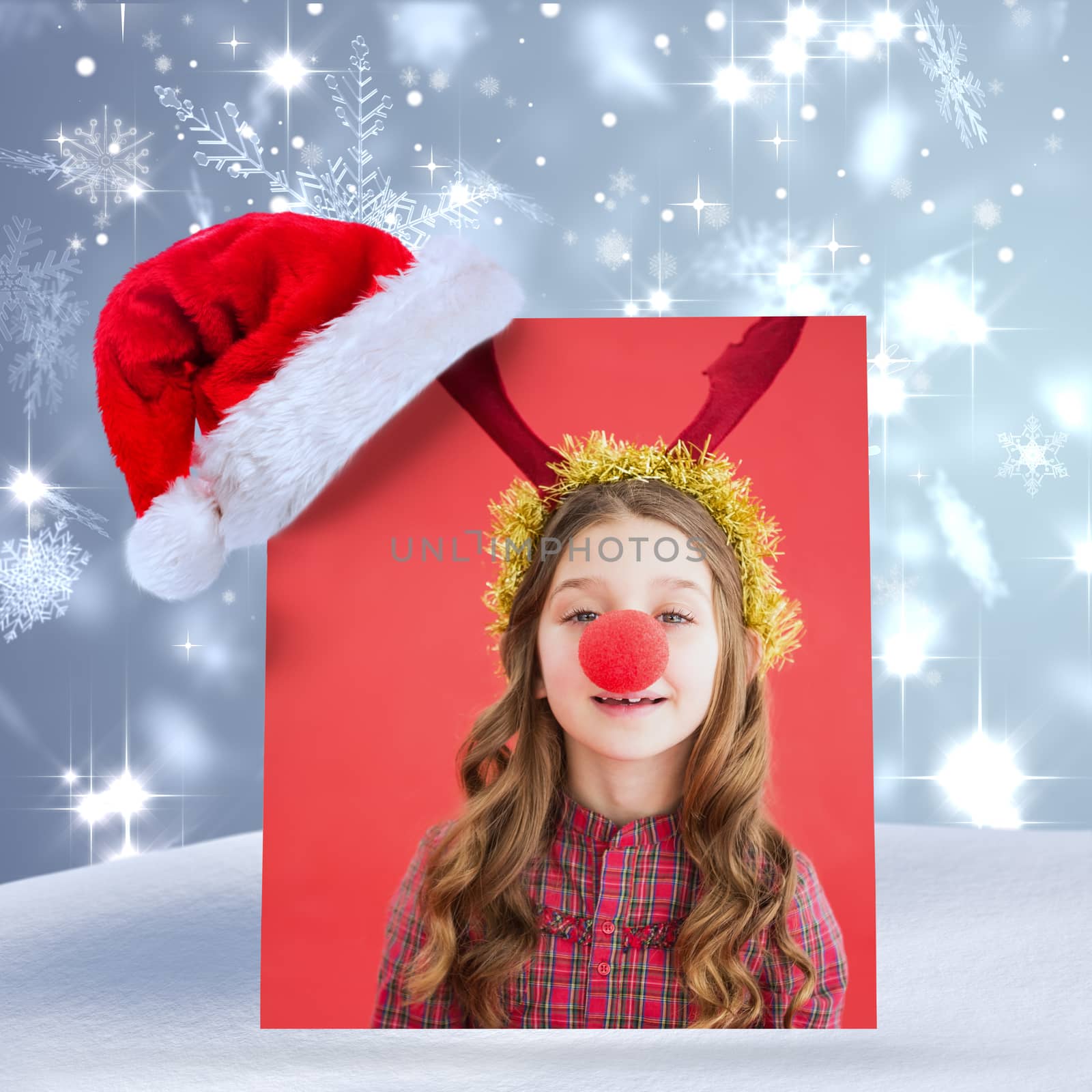 Festive little girl wearing red nose against snowflake design shimmering on blue