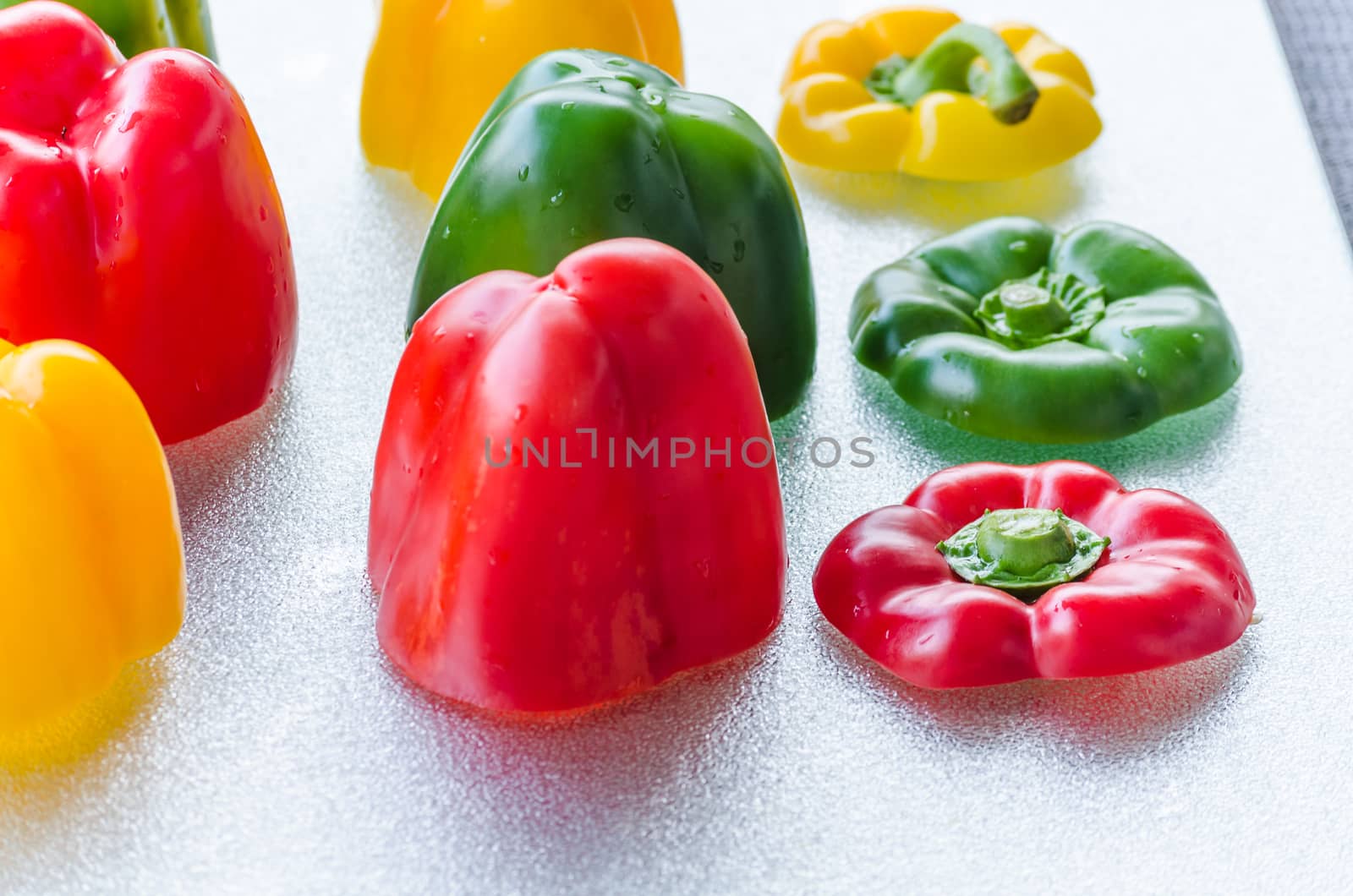 Yellow, Red, Green Bell Pepper cut on a silver platter.