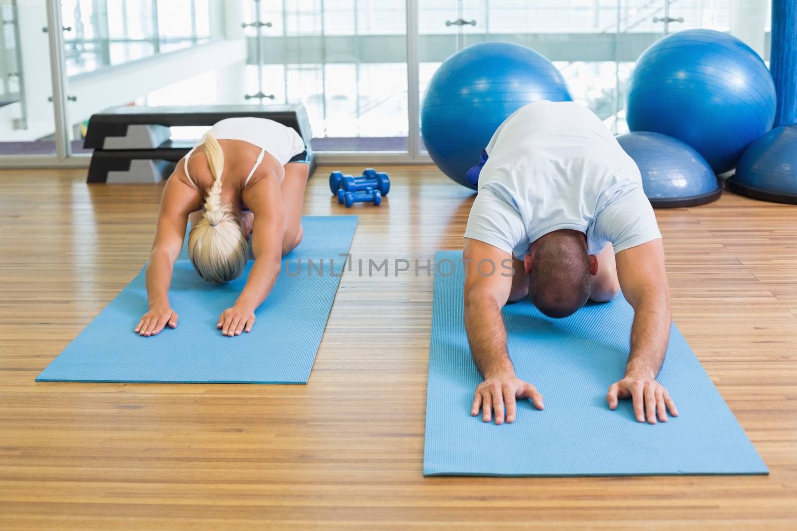 Sporty young couple in bending posture at the fitness studio