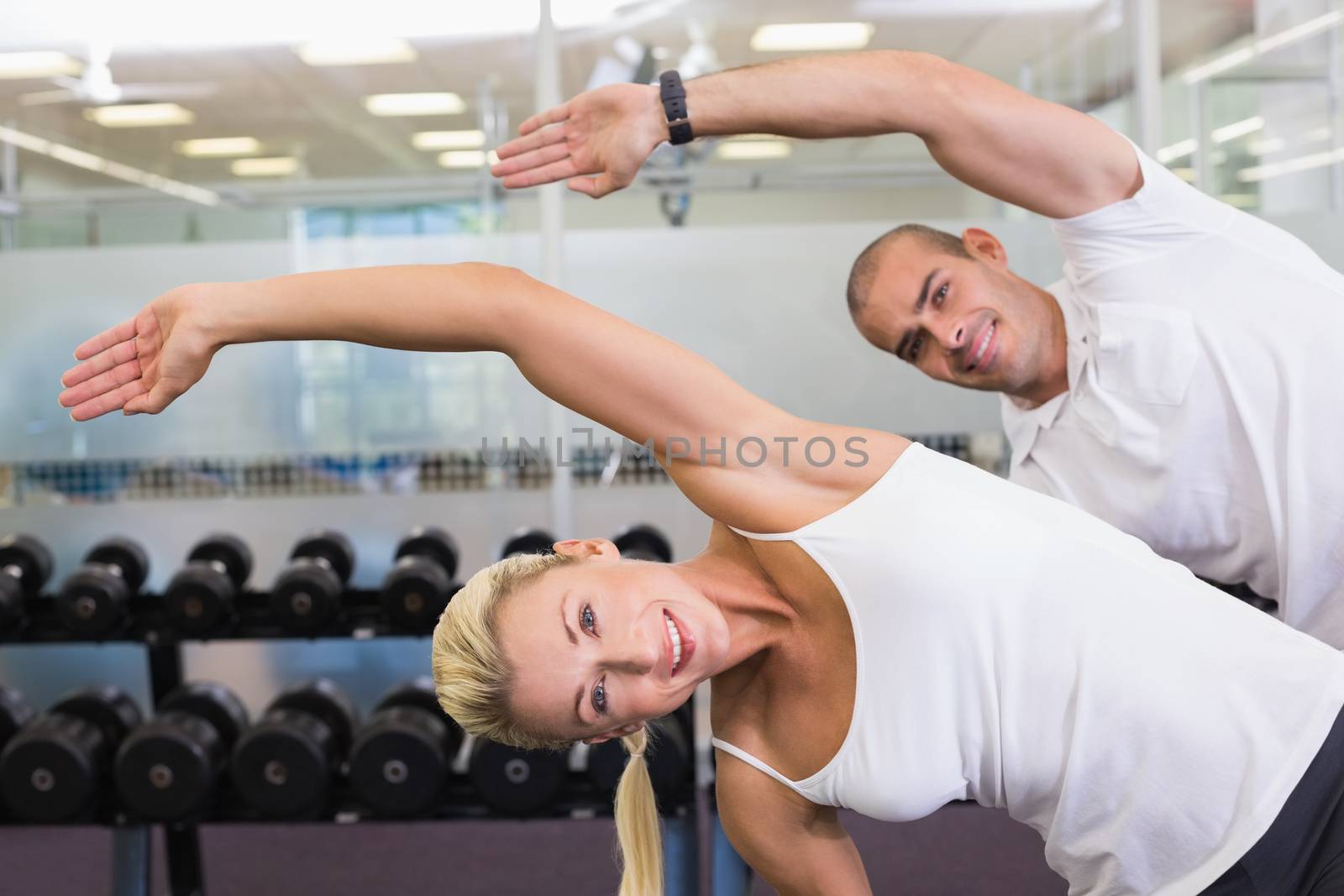 Happy couple stretching hands in yoga class by Wavebreakmedia