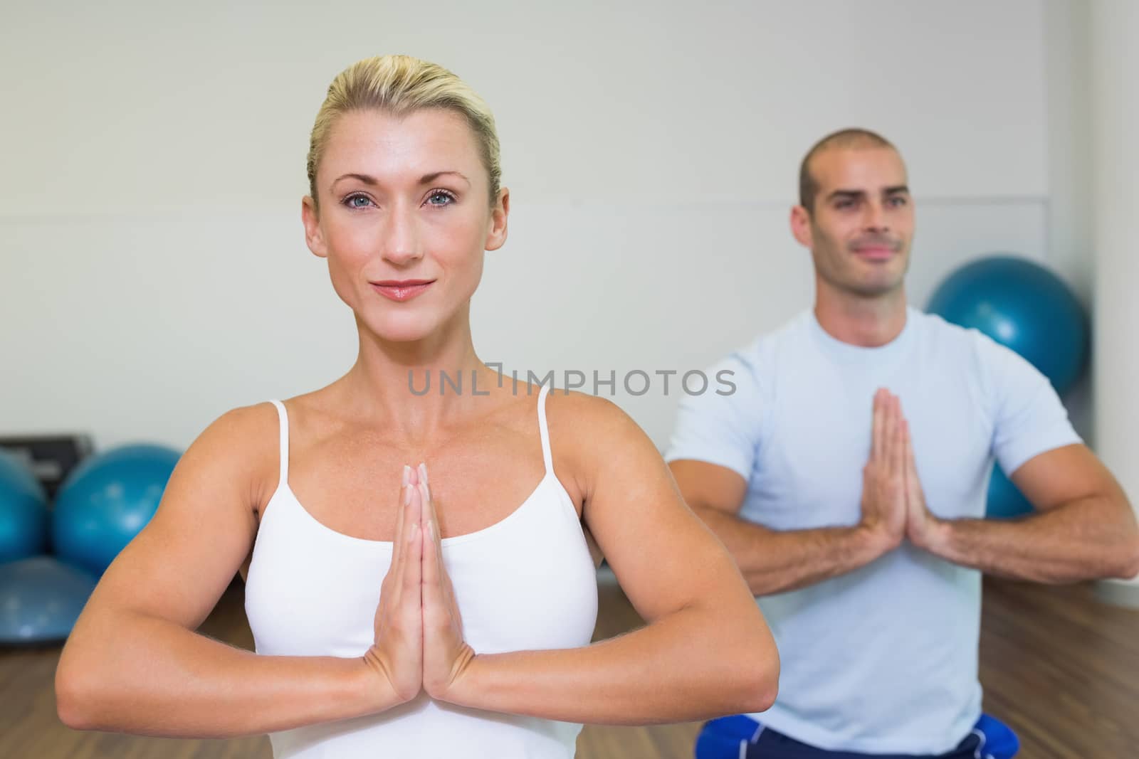 Portrait of a sporty young couple with joined hands at fitness studio