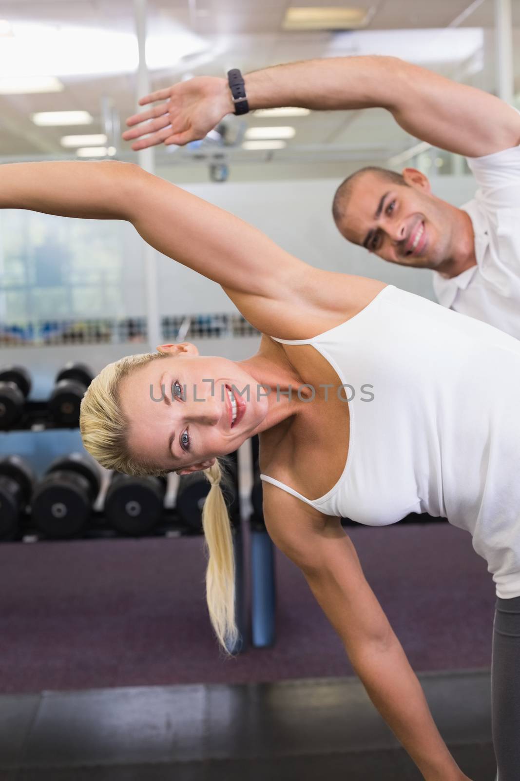 Happy couple stretching hands in yoga class by Wavebreakmedia