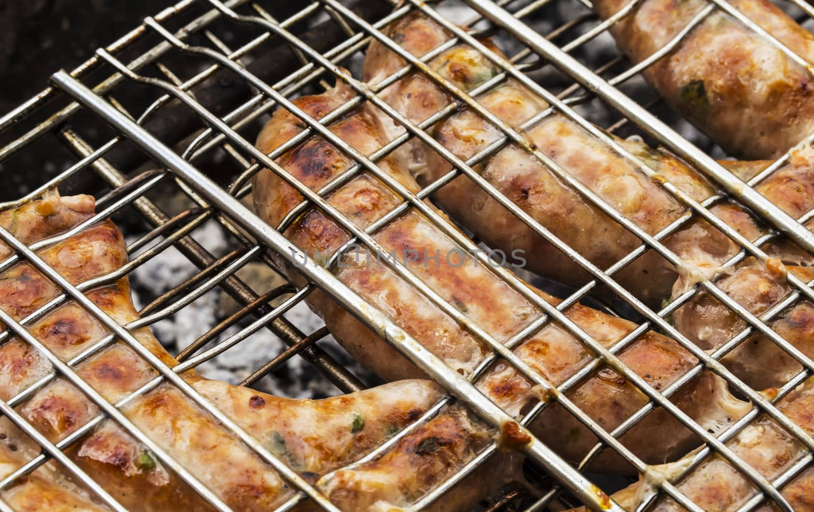 grilled sausage on the flaming grill isolated