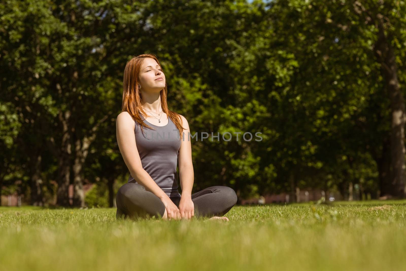 Portrait of a pretty redhead sitting carefree in sunshine