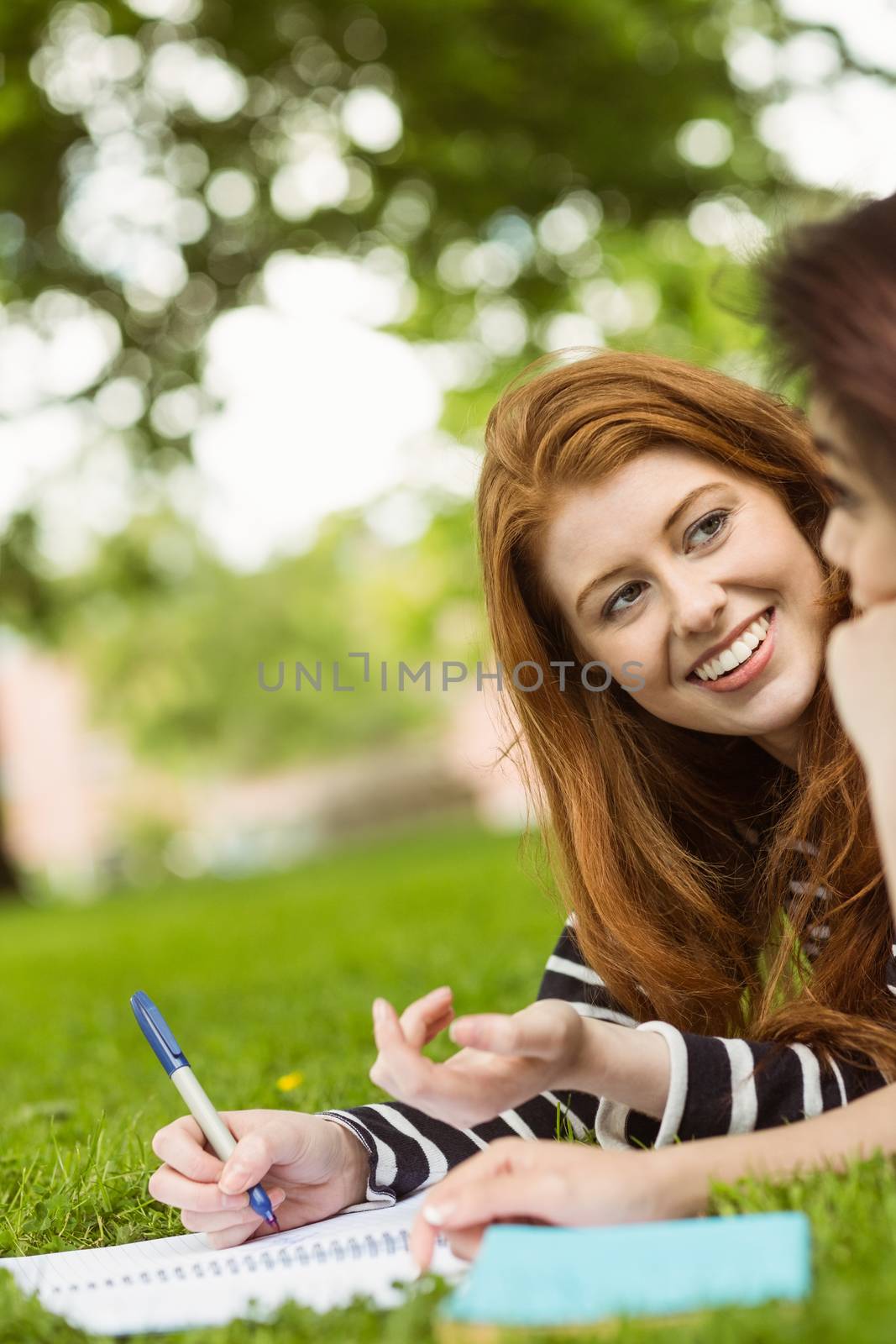 Relaxed female students with books in park by Wavebreakmedia