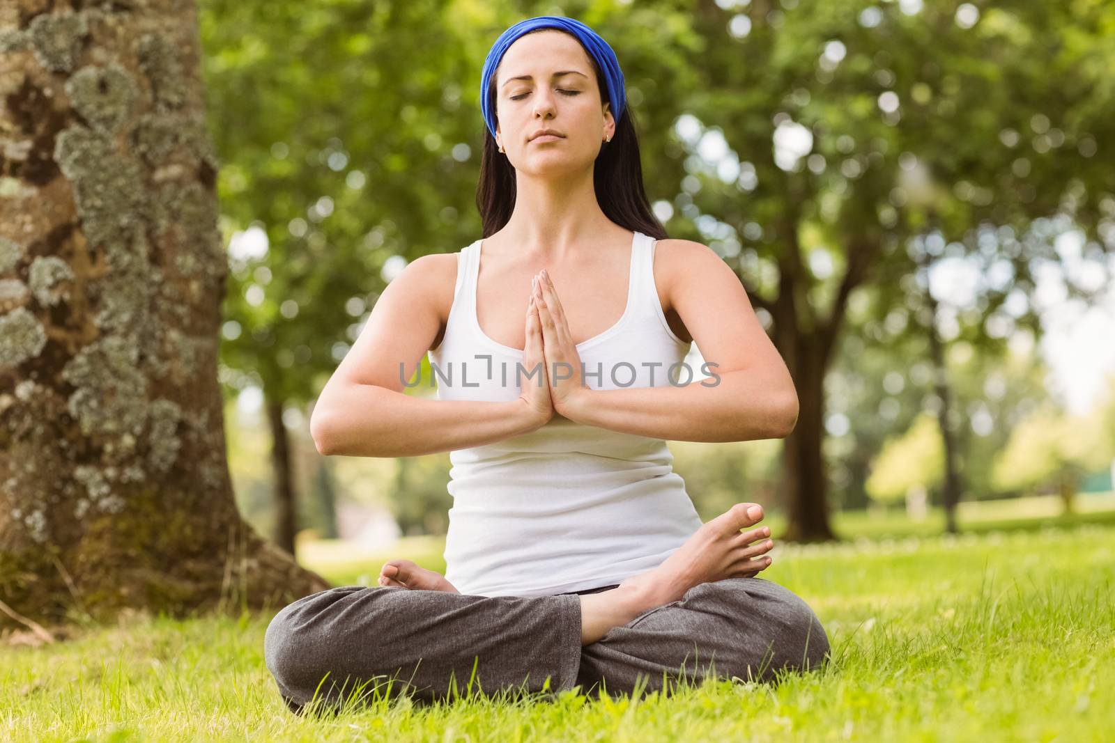 Brunette sitting in lotus pose with hands together by Wavebreakmedia