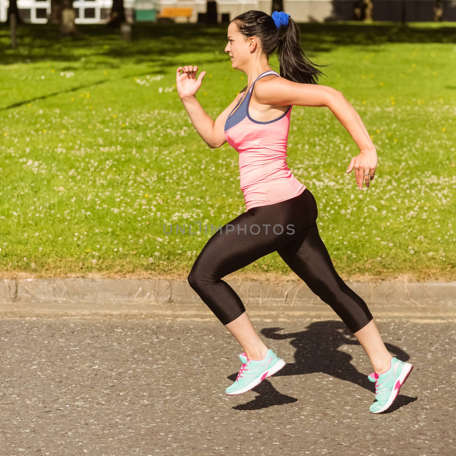 Fit brunette going faster on path in the park