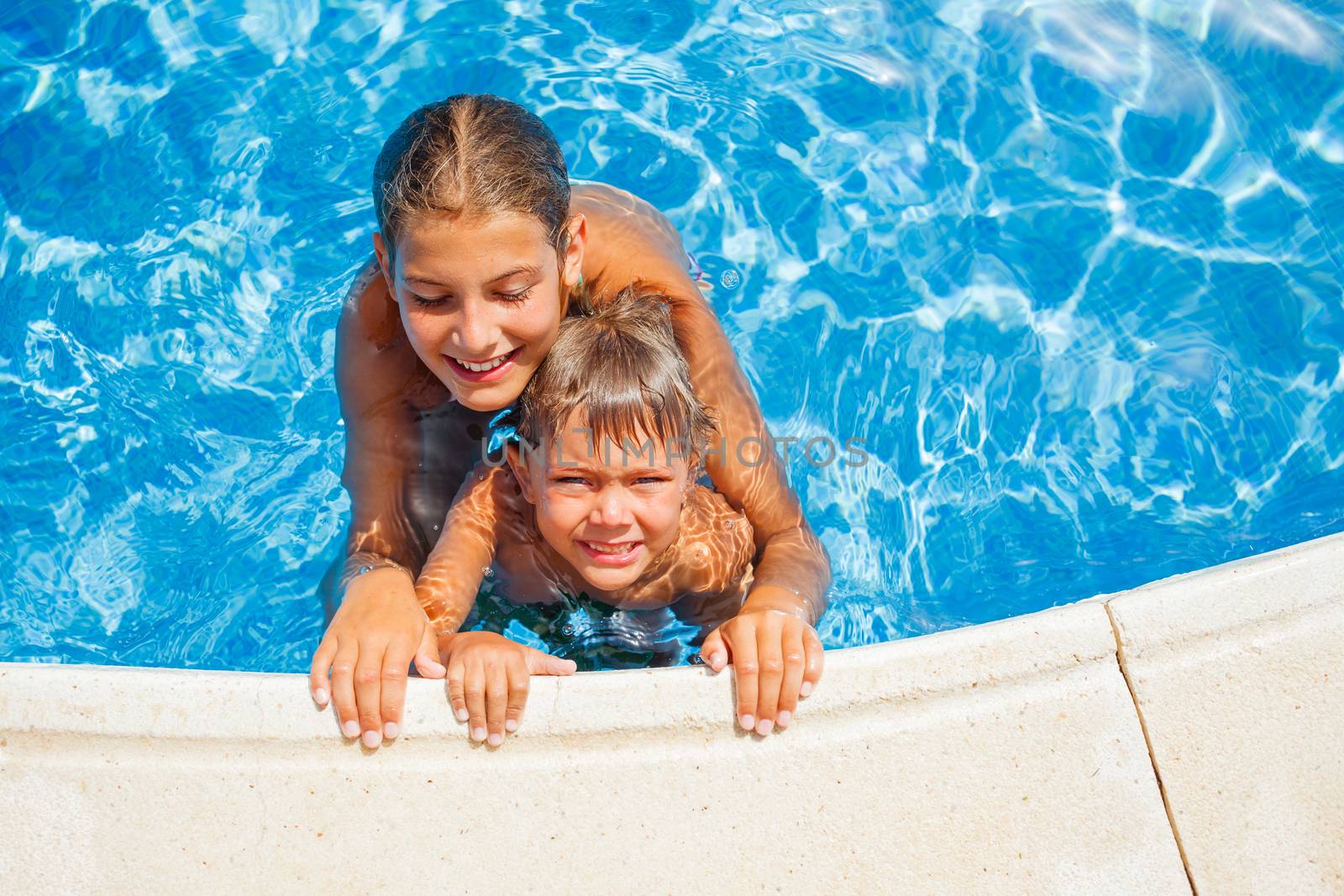 Happy kids swimming and snorking in the swimming pool