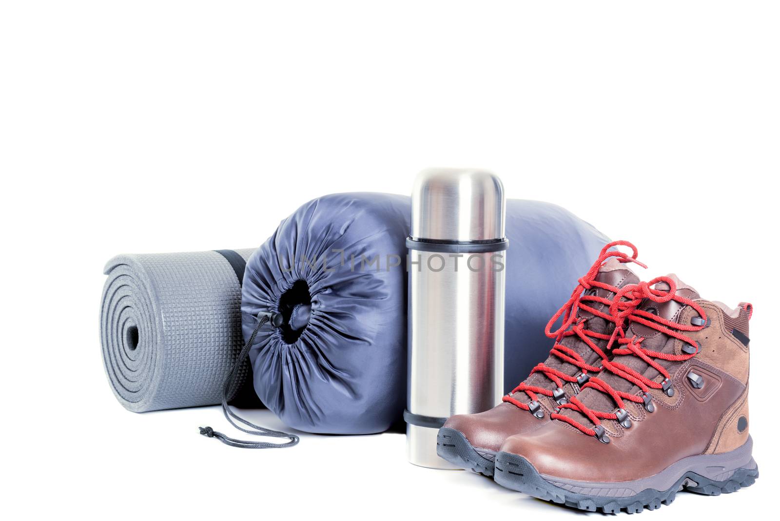 Hiker equipment: pair of mountain boots, thermo flask, sleeping bag and mat on white background