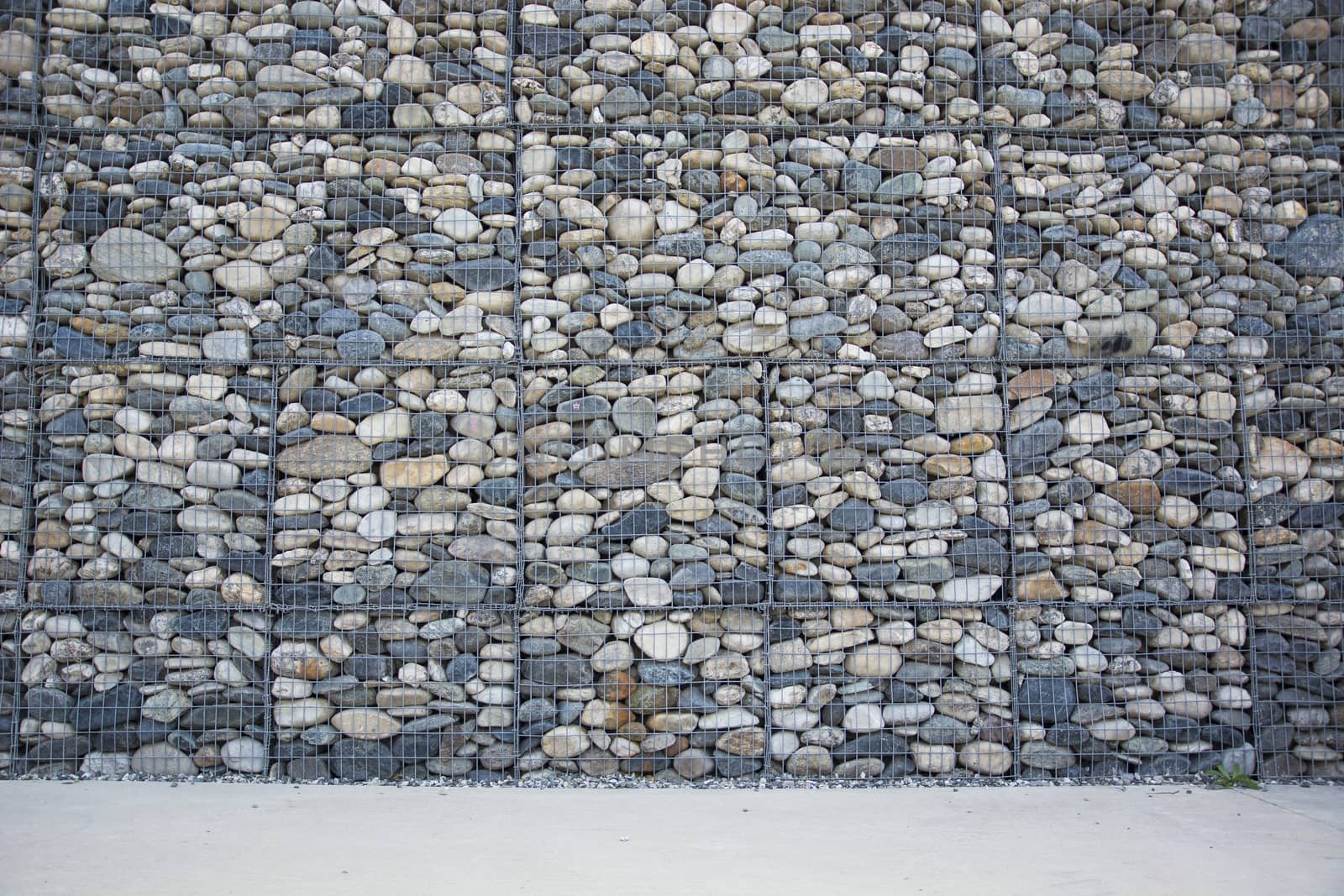 Empty wall made of stones and concrete pavement, horizontal orientation