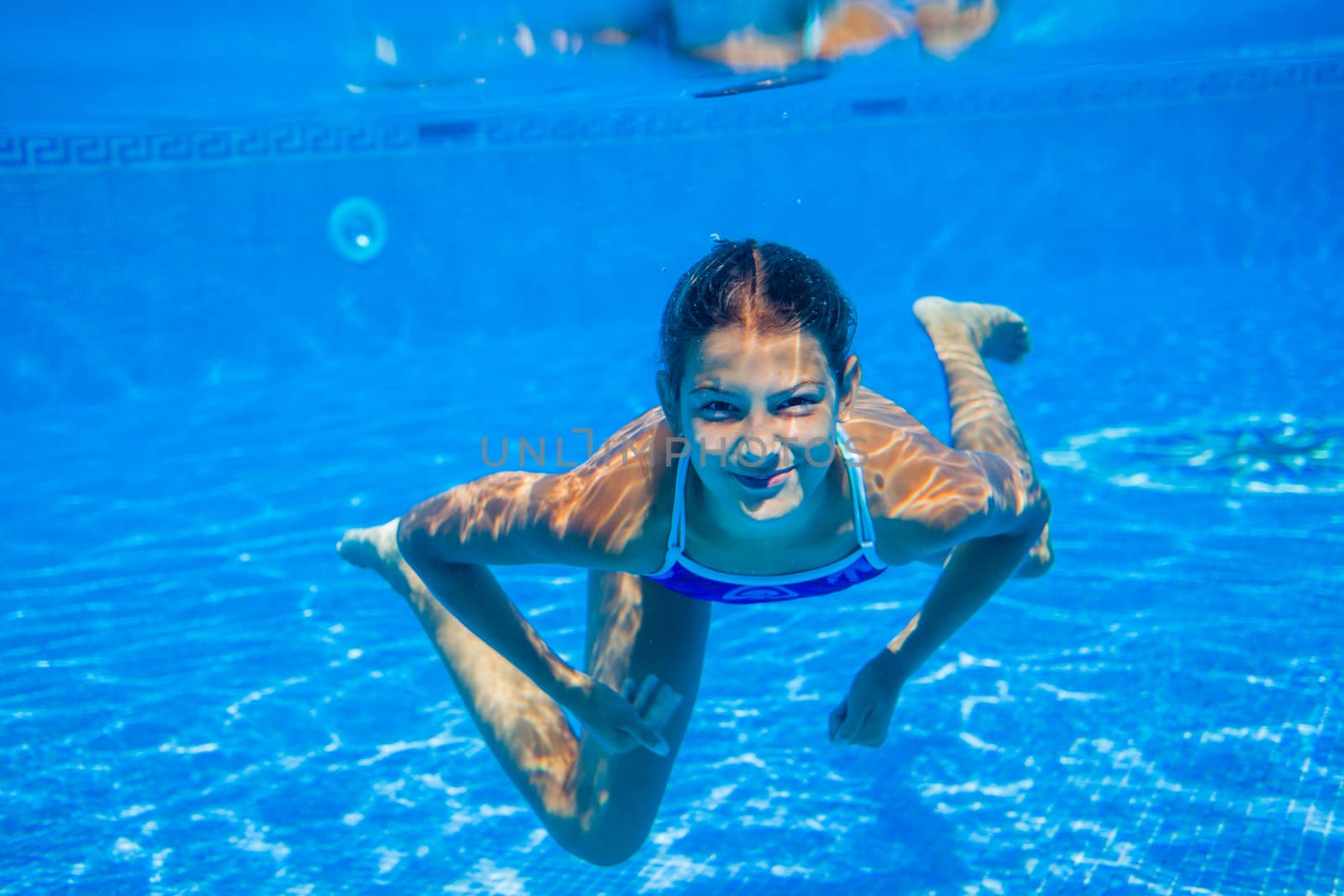 Underwater happy cute girl in swimming pool