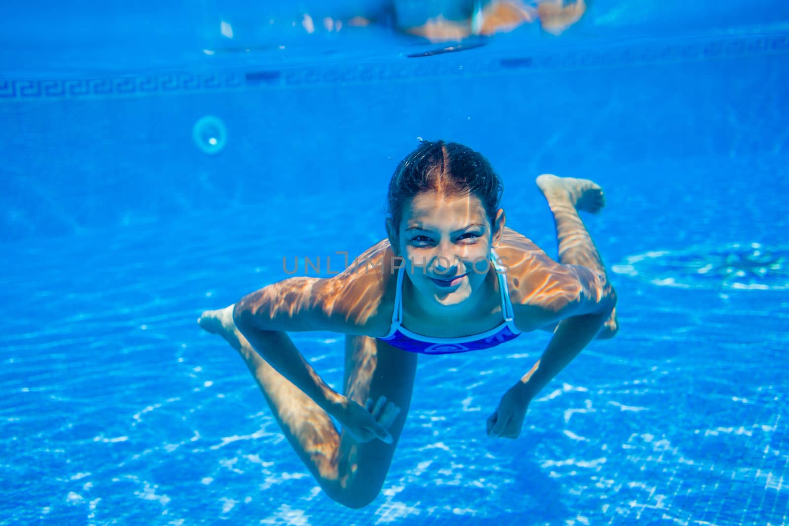 Underwater happy cute girl in swimming pool