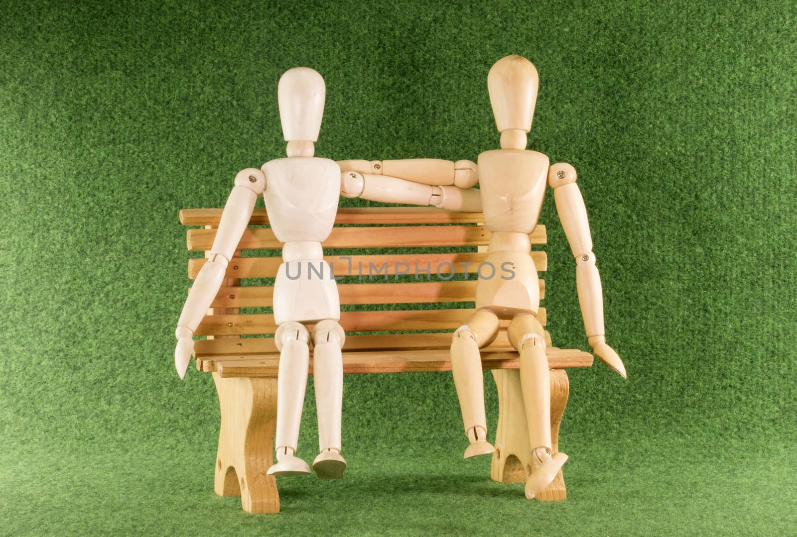 two wooden puppet toys as love couple on bench