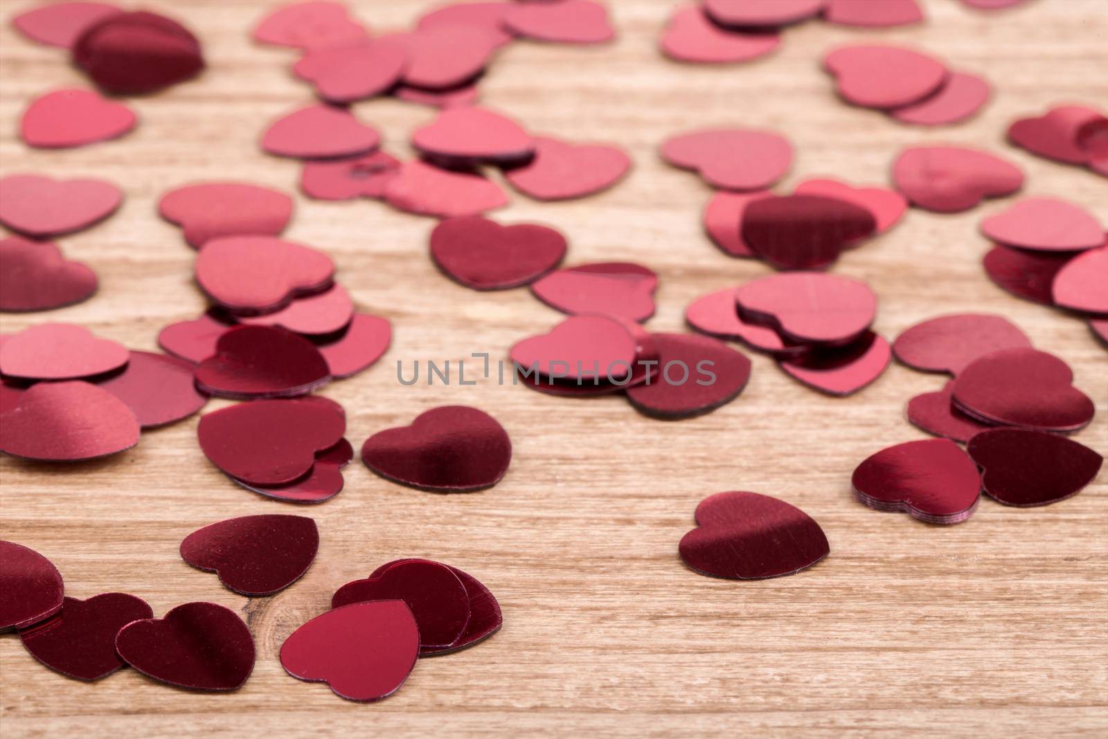 small red hearts confetti on wooden background, calentine love concept