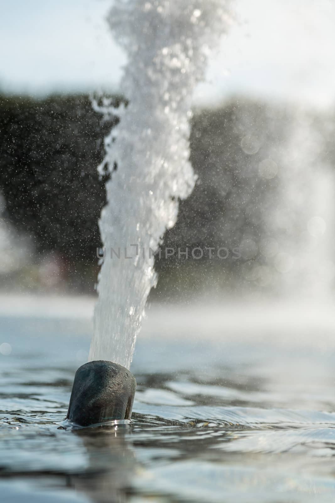 High pressured water gushing out of a pipe in a fountain