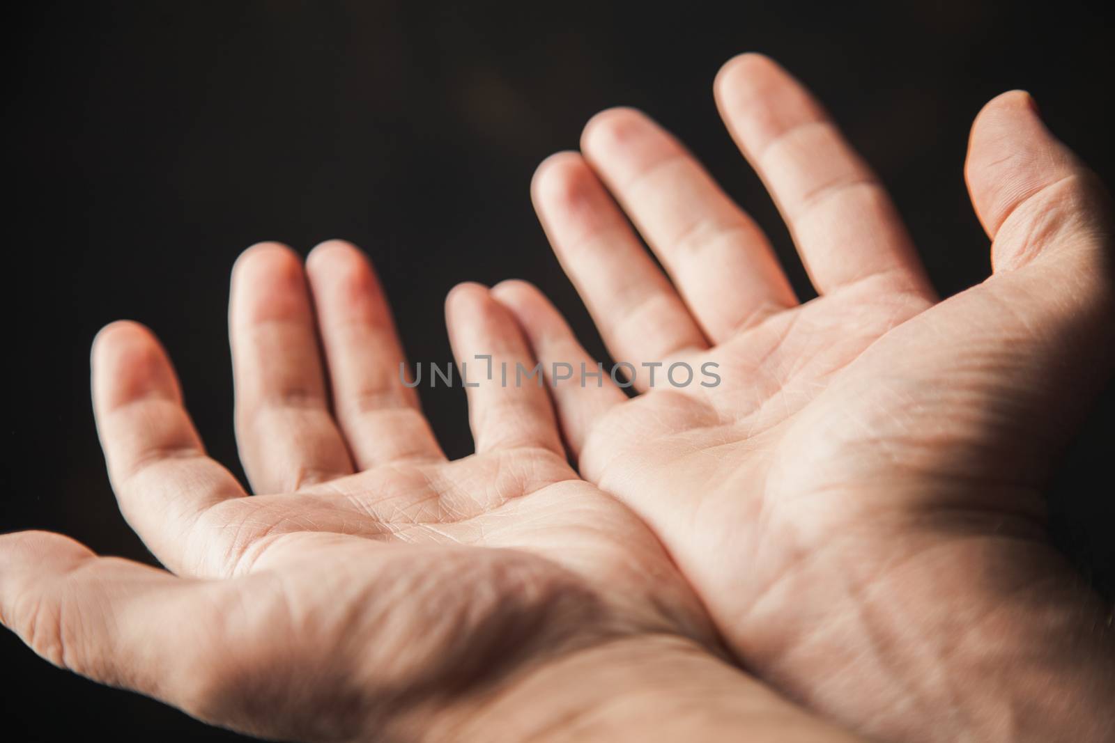 hands begging on a brown background