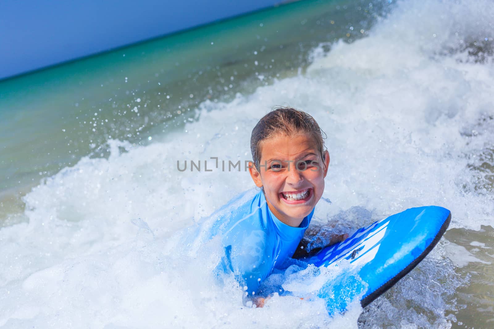 Teenage girl in blue has fun surfing