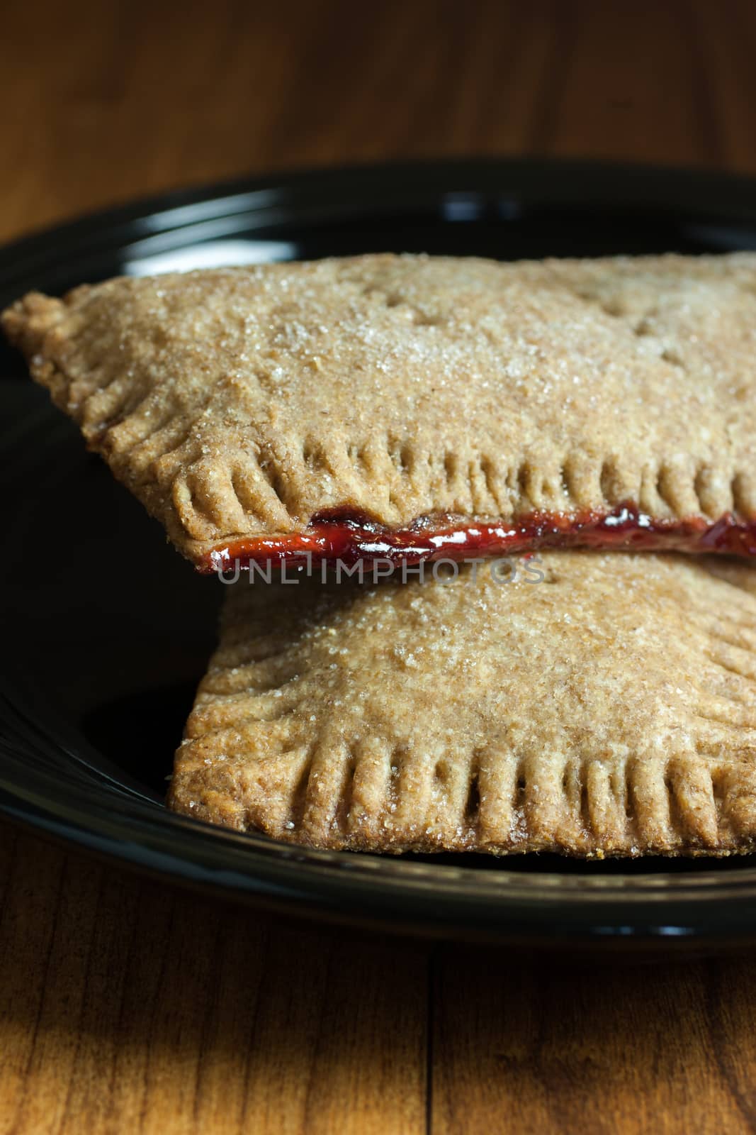 Whole wheat toaster pastries, lightly dusted with sugar crystals and filled with raspberry filling.