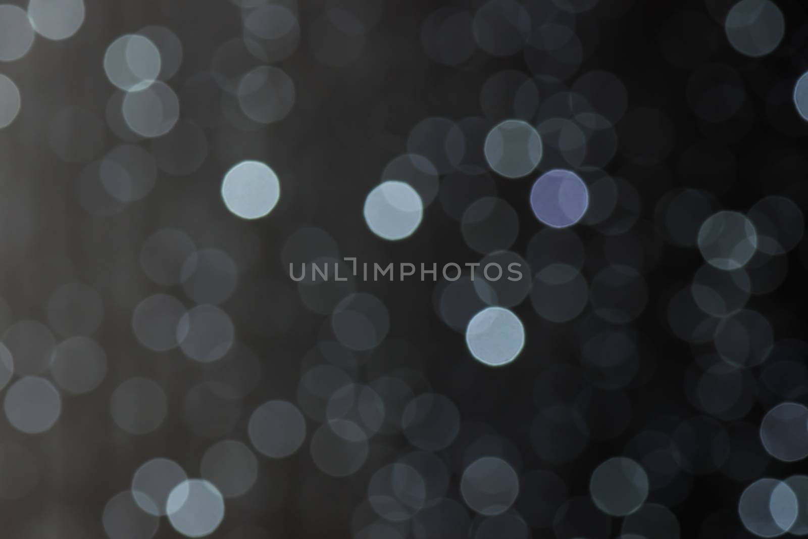 Defocused little lights of clear colors forming soft circles in soft fusion with the background 