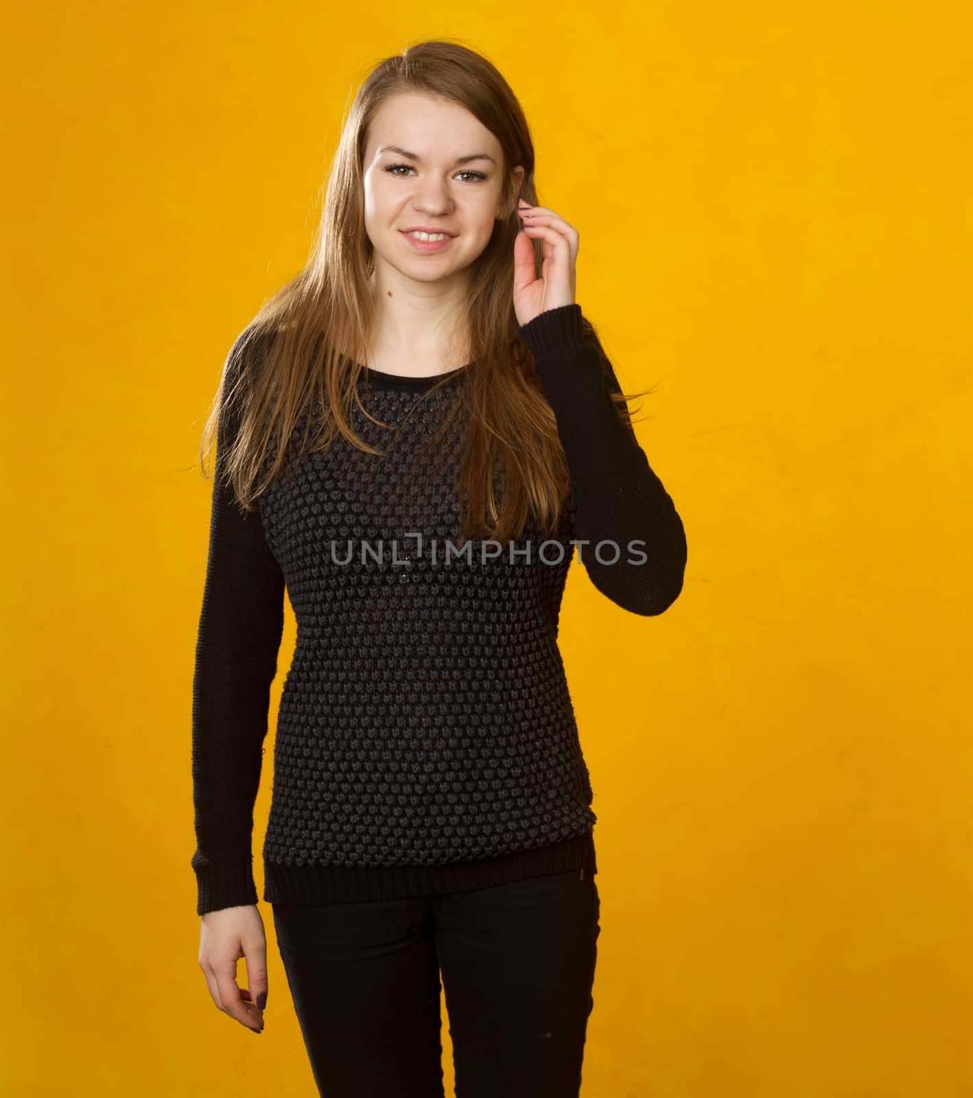 portrait of a beautiful  girl on a background of orange wall