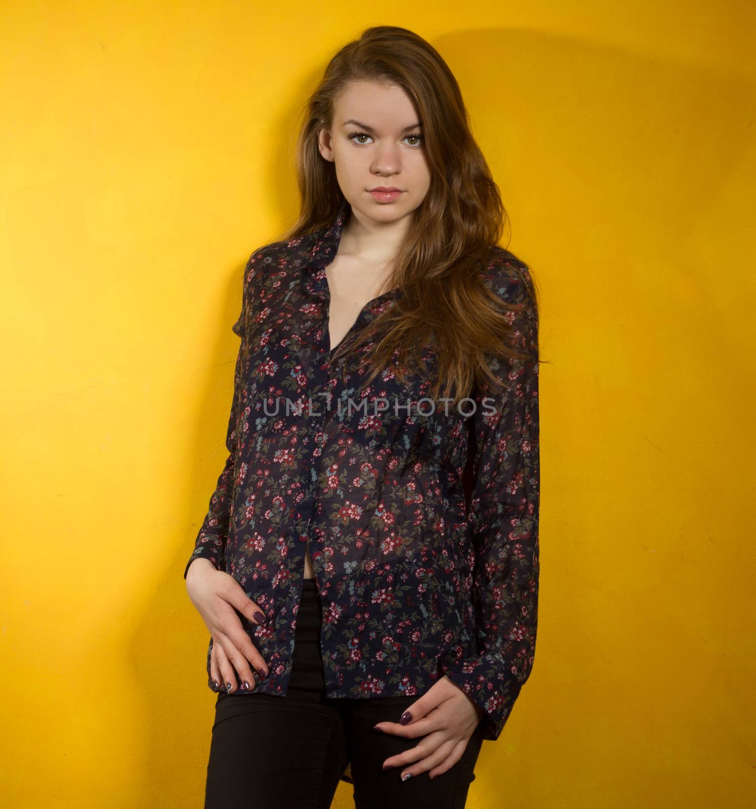 girl stands near the yellow wall. large shadow