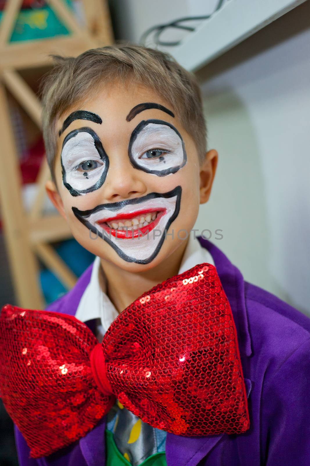 Close-up portrait of cute little boy in clown makeup