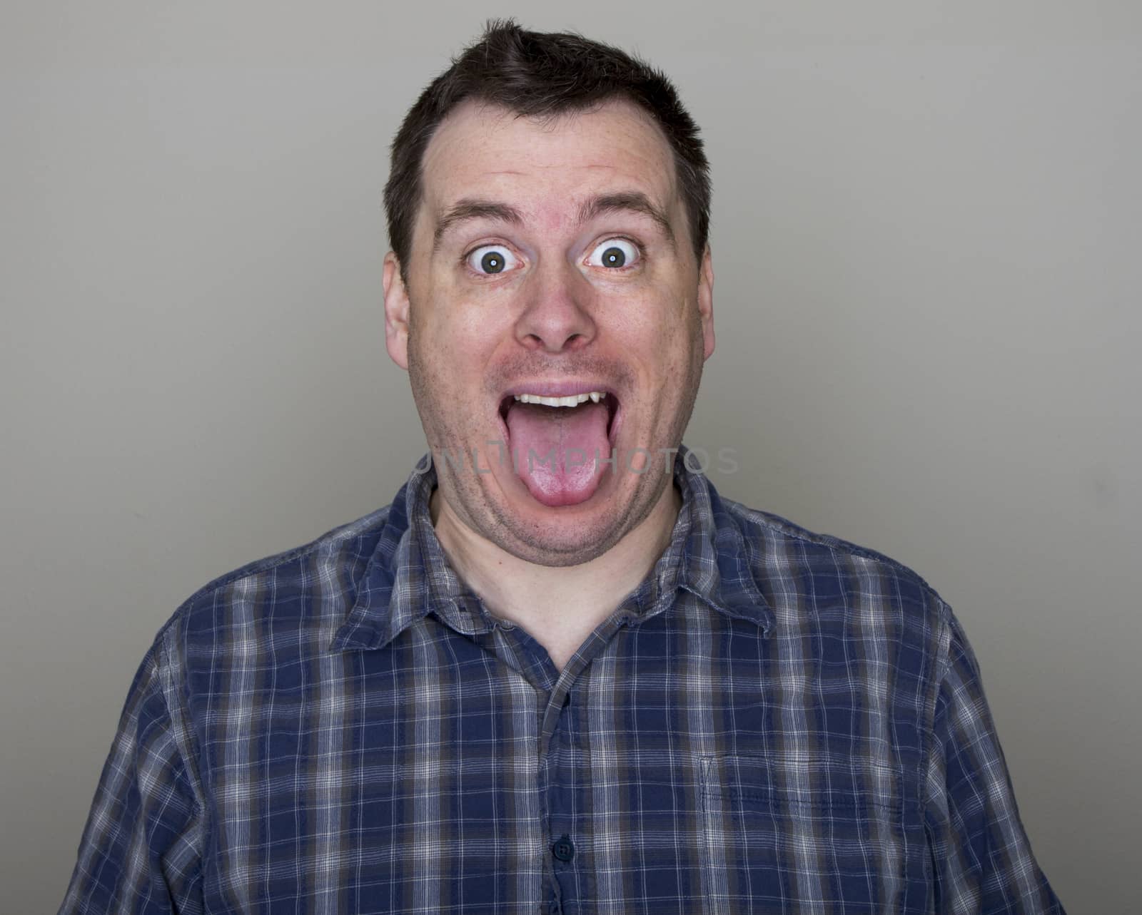 Man holding his mouth open with his tongue hanging out.