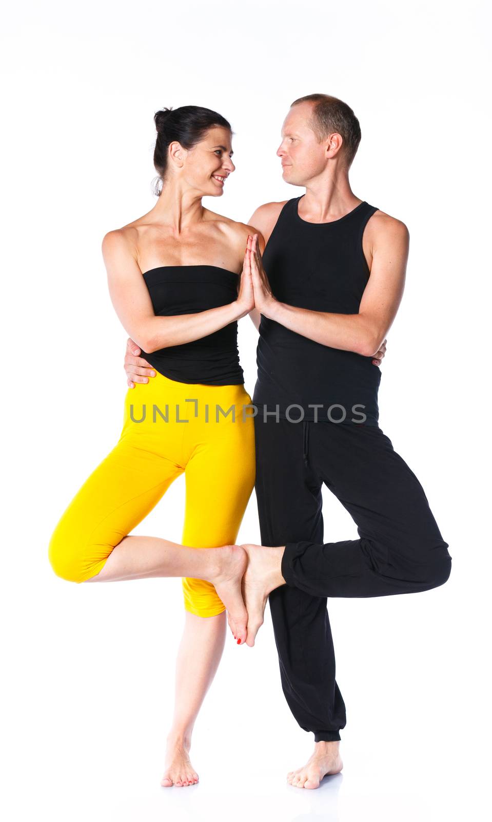 Young couple doing yoga. Isolated on white backgraund