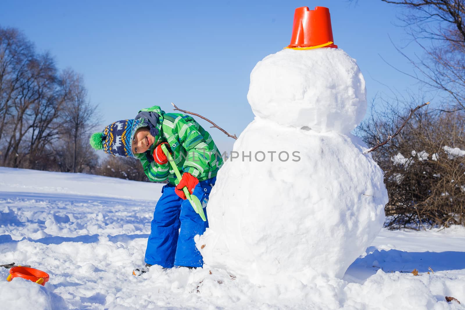 Winter, play, fun - Little boy making a snowman