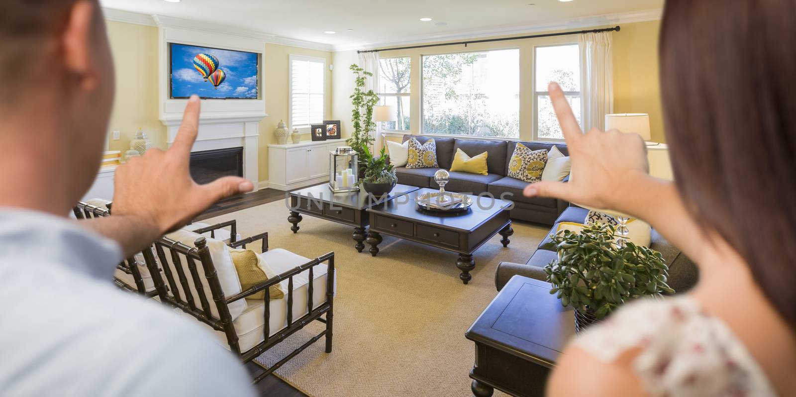 Young Couple Framing Their Hands of Beautiful Home Interior Living Room.