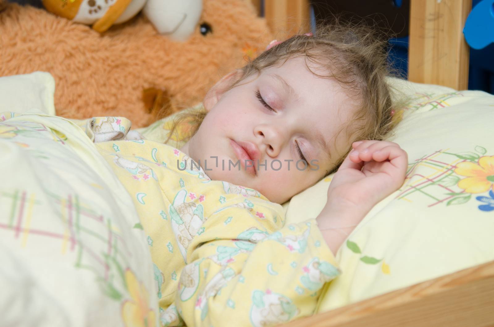 Three year old girl sweetly asleep in his crib in the nursery