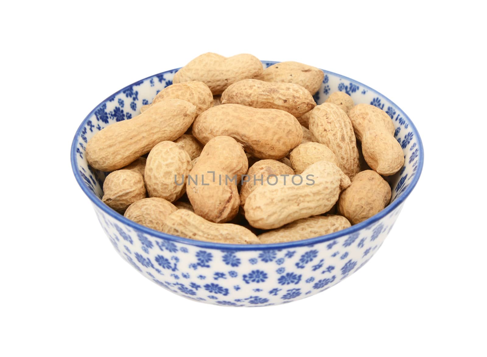 Monkey nuts in a blue and white porcelain bowl with a floral design, isolated on a white background