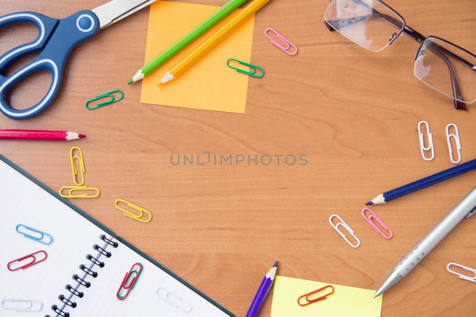 scissors, glasses, paper clips, pen, pencil,notebook on wooden surface