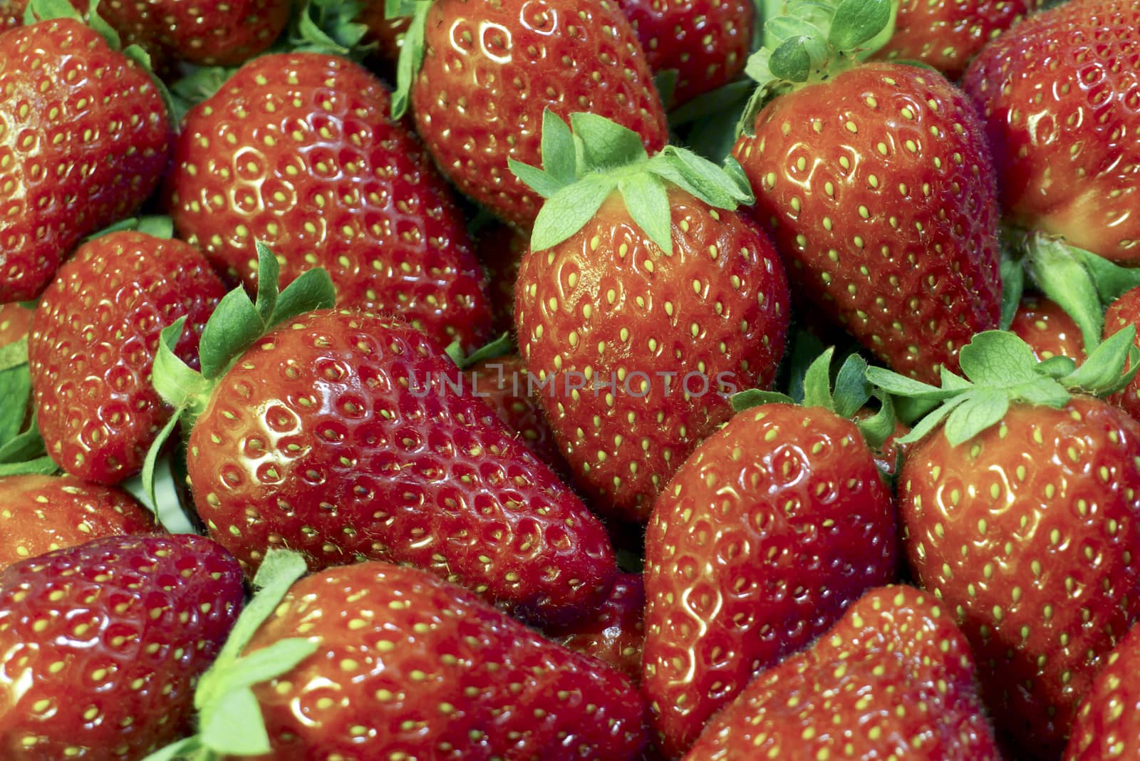 Close-up of fresh scattered strawberrys at street market in summer background.