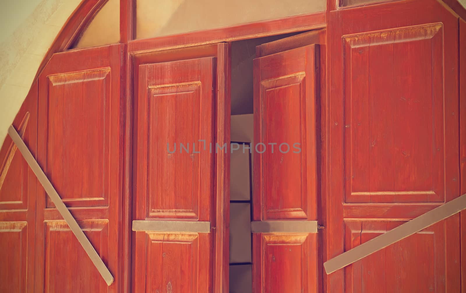 Old wooden doors with the original design and the castle in the old house on the coast of the island of Crete, Greece.