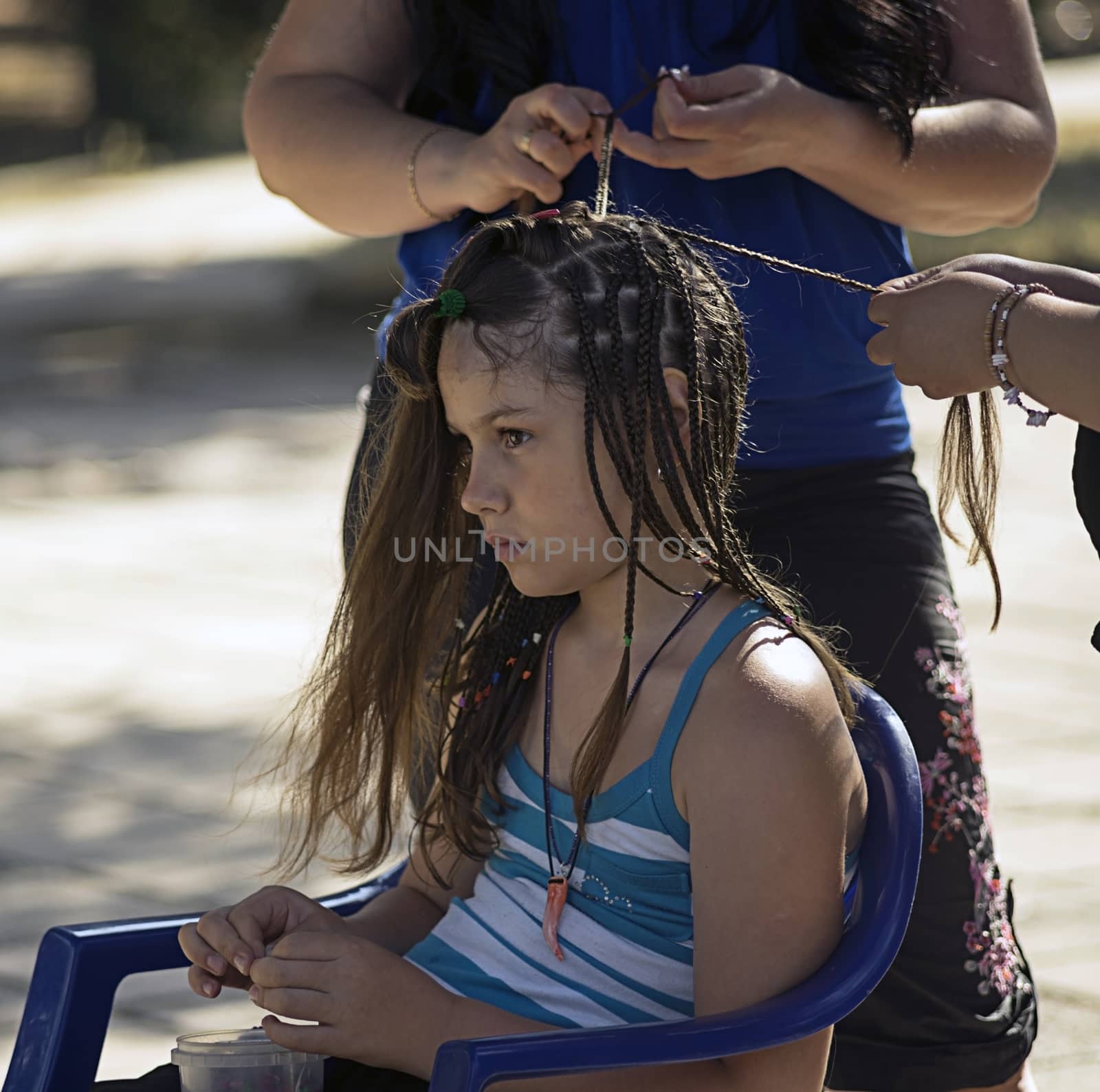 The girl braid plaits on the street.