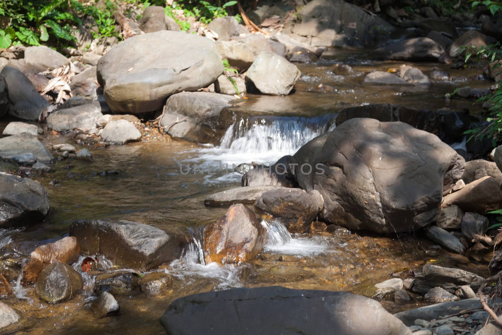 Waterfall that flows down from the mountains. Streams of water flowing down from the mountains. There is always a small stone waterfall.