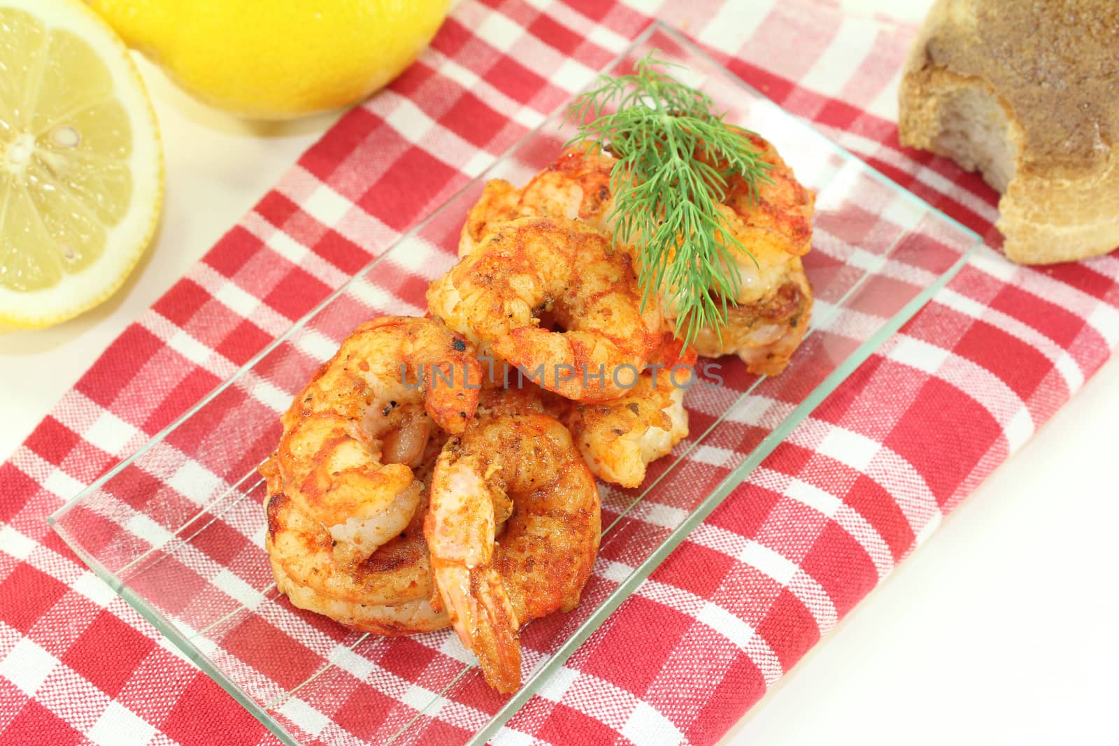 fried shrimp on a plate with lemon and dill