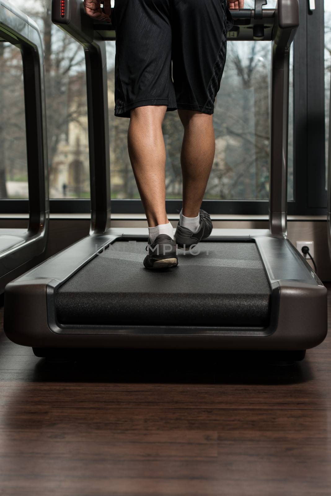Fitness Man Running On Treadmill by JalePhoto