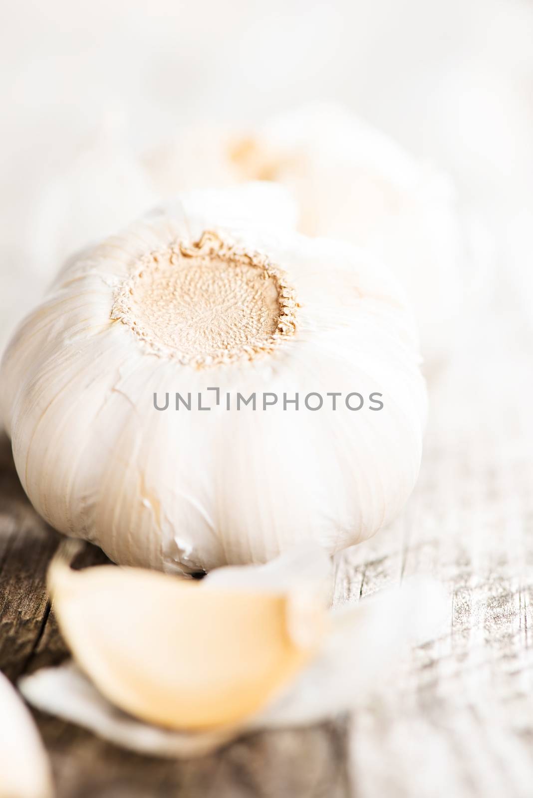 Garlic on wooden table up side down by Nanisimova