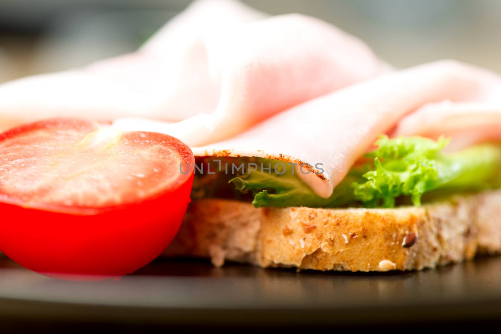 Open-faced  sandwich with ham, tomato and salad leaves