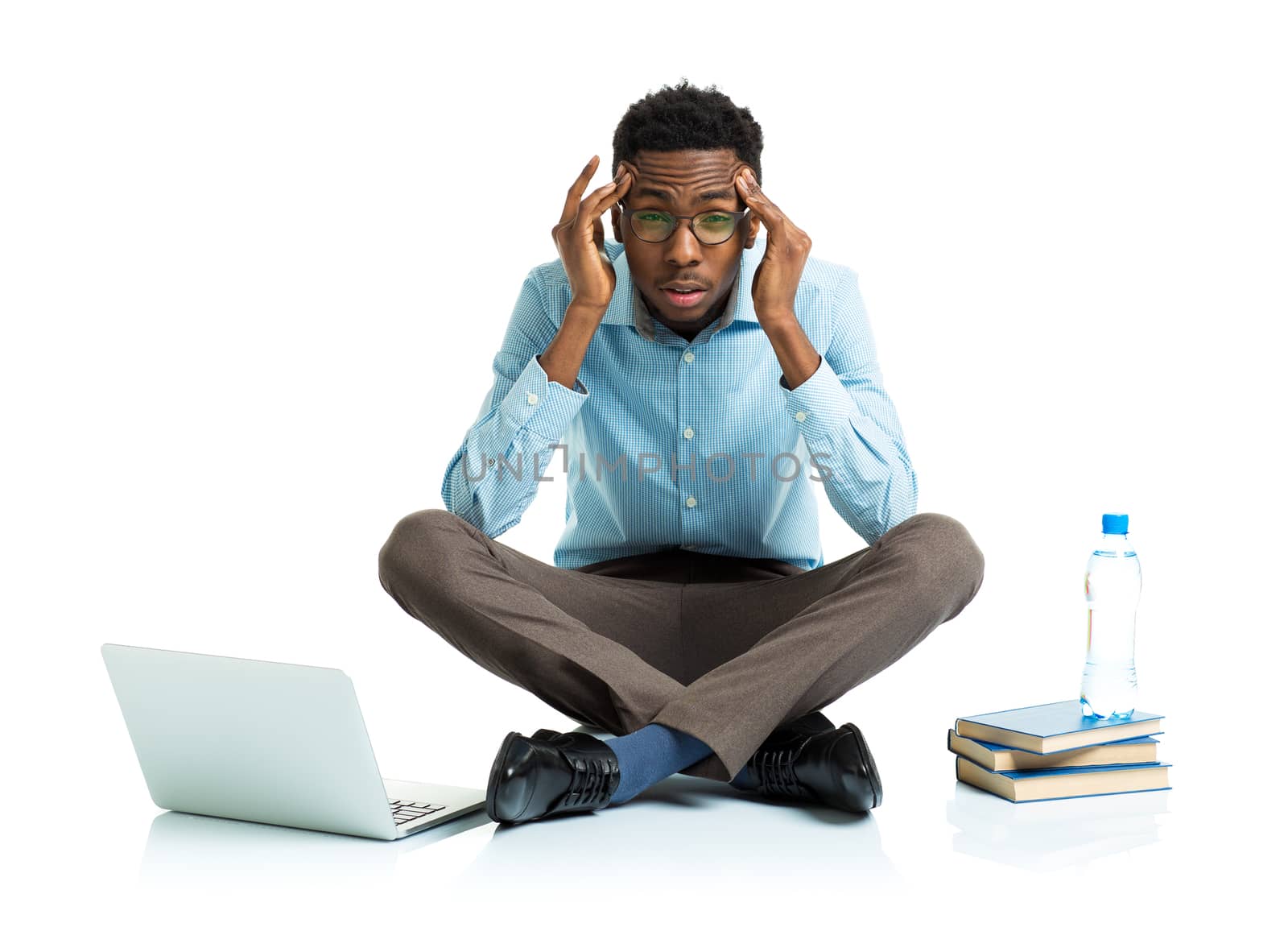 African american college student in stress sitting with laptop, books and bottle of water on white background