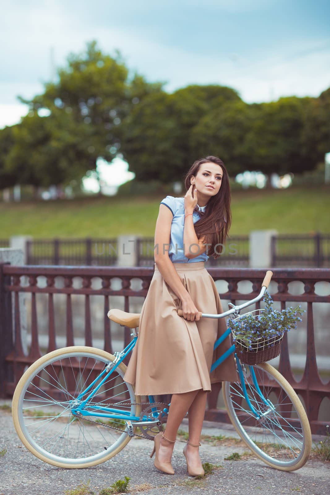 Young beautiful, elegantly dressed woman with bicycle. Beauty, fashion and lifestyle