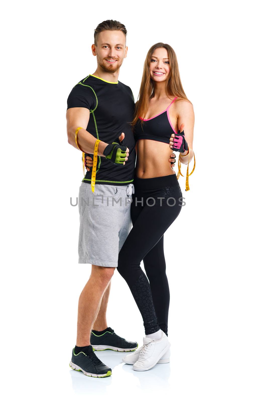 Happy sport couple - man and woman with measuring tape on the white background