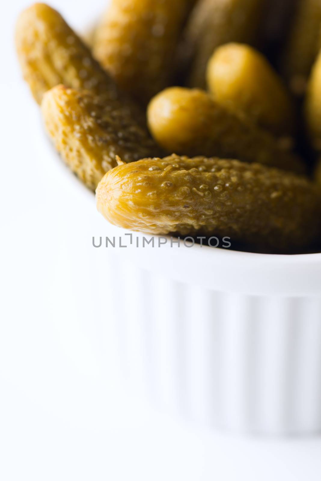 Tiny dill pickles in bowl macro by Nanisimova