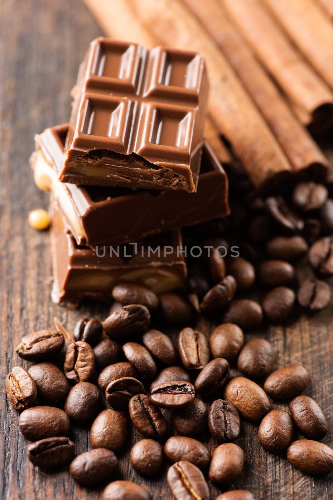 Chocolate bar and cofee beans on wooden table by Nanisimova