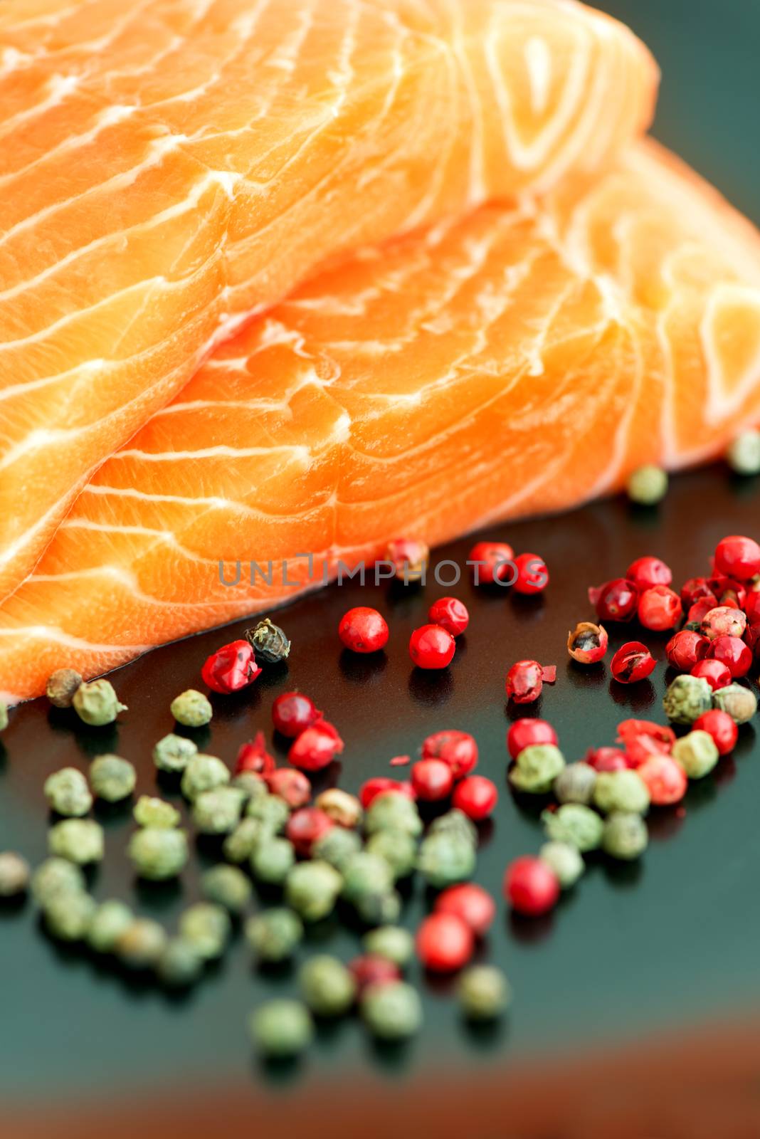 Raw salmon ready to cook close up on black surface by Nanisimova