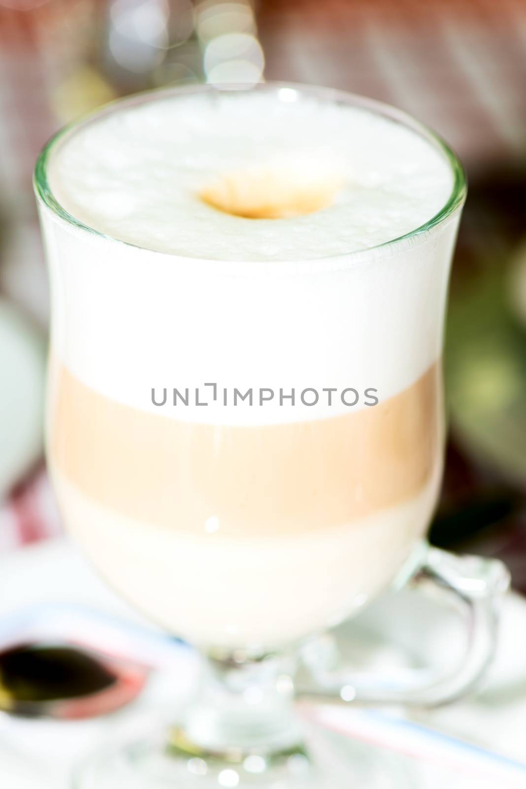 Layered cappuccino in a clear glass mug close up