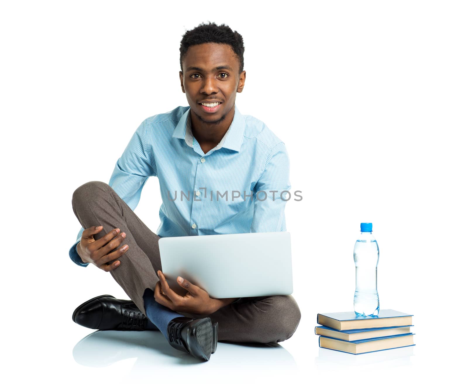 Happy african american college student sitting with laptop on white background